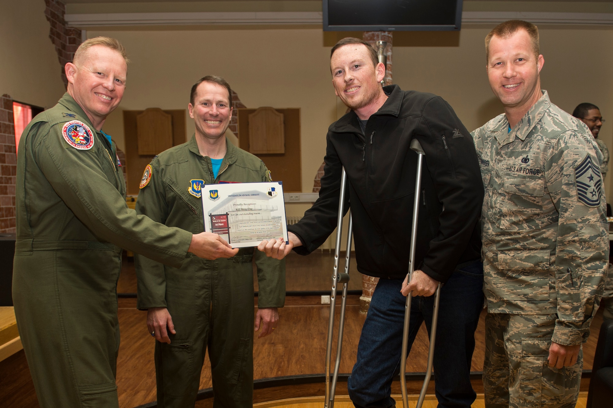 Spangdahlem's leadership team presents Airman 1st Class Beau Clay, 52nd Civil Engineer Squadron water and fuel systems apprentice, with a certificate for winning first place in the Dorm of the Quarter awards held in the Brick House at Spangdahlem Air Base, Germany, April 14, 2017. Each quarter an Airman is recognized for the best dorm room on base. (U.S. Air Force photo by Airman 1st Class Preston Cherry)