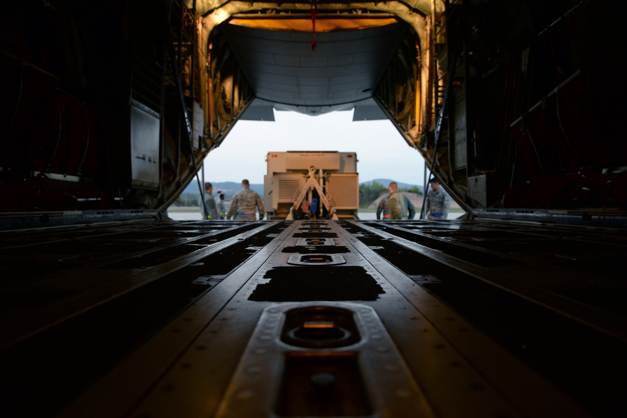 Airmen from the 1st Combat Communication Squadron along with 37th Airlift Squadron load a Tactical Air Navigation system onto a C-130 aircraft April 15, on Ramstein Air Base, Germany. The TACAN works by sending and receiving signals from aircraft notifying them of their bearing and distance in relation to the base. (U.S. Air Force photo by Airman 1st Class D. Blake Browning)