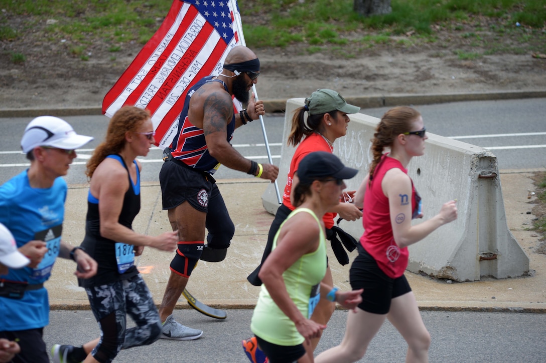 Retired Marine Corps Sgt. Jose Luis Sanchez carries the U.S. flag while participating in the 121st Boston Marathon in Brookline, Mass., April 17, 2017. Sanchez lost his leg to an improvised explosive device during a patrol in Afghanistan, Oct., 22, 2011. Army National Guard photo by Staff Sgt. Steven C. Eaton
