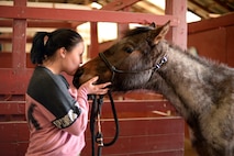 Bobbie Scheffler, 5th Force Support Squadron missile chef, kisses her two-year-old horse Athena on the nose at the Dufresne Riding Club Stables at Minot Air Force Base, N.D., April 11, 2017. One of Dufresne Riding Club goals is to raise the moral of those on base by giving them a place to relax and feel at ease. (U.S. Air Force photo/Airman 1st Class Austin M. Thomas)