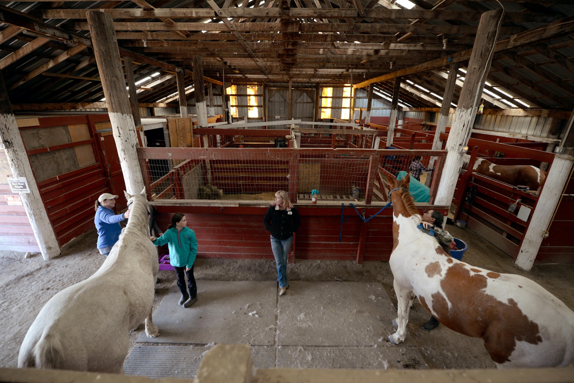 Horses and their owners relax at the Dufresne Riding Club Stables at Minot Air Force Base, N.D., April 11, 2017. The stables help Airmen pursue hobbies and passions that may be difficult to have as a military member. (U.S. Air Force photo/Airman 1st Class Austin M. Thomas)