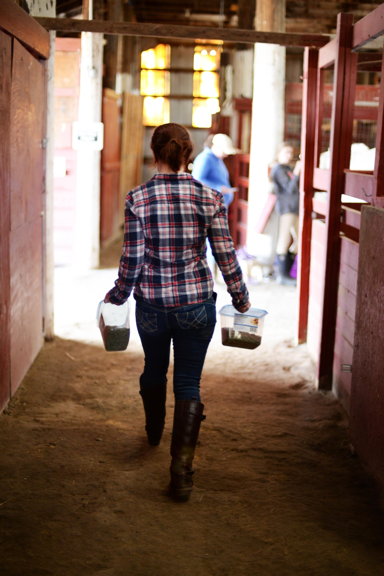 Tori Halbasch, spouse of Senior Airman Nick Halbasch, 5th Operations Support Squadron work master, gets grain for her horse Dante at the Dufresne Riding Club Stables at Minot Air Force Base, N.D., April 11, 2017. The stables were first started in 1972. (U.S. Air Force photo/Airman 1st Class Austin M. Thomas)