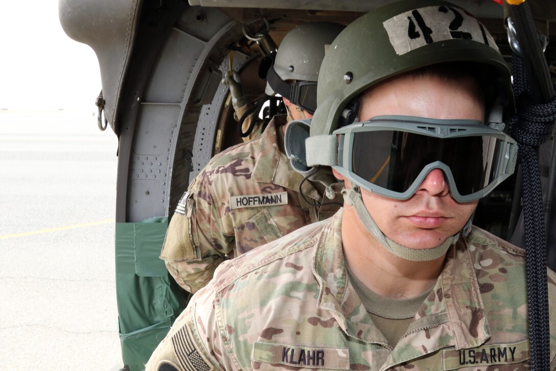 Army Spc. Steven Klahr, front, and Spc. Jacob Hoffman, rear, listen to instructions before they rappel out of a UH-60 Black Hawk helicopter during day nine of the air assault course at Camp Buehring, Kuwait, April 13, 2017. Klahr is a air traffic controller assigned to the 77th Combat Aviation Brigade and Hoffman is a multiple launch rocket system crewmember assigned to the 169th Field Artillery Brigade. Army photo by Sgt. Tom Wade