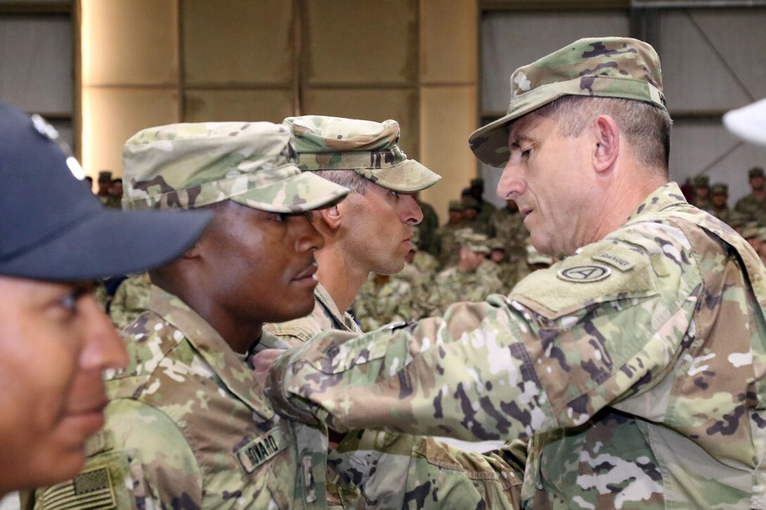 Army Maj. Gen. William Hickman, right, the deputy commanding general of Army Central, pins air assault wings on Army Sgt. Carl Howard, an honor graudate from the air assault course at Camp Beuhring, Kuwait, April 14, 2017. Howard is a combat medic with the 215th Brigade Support Battalion. Army photo by Sgt. Tom Wade