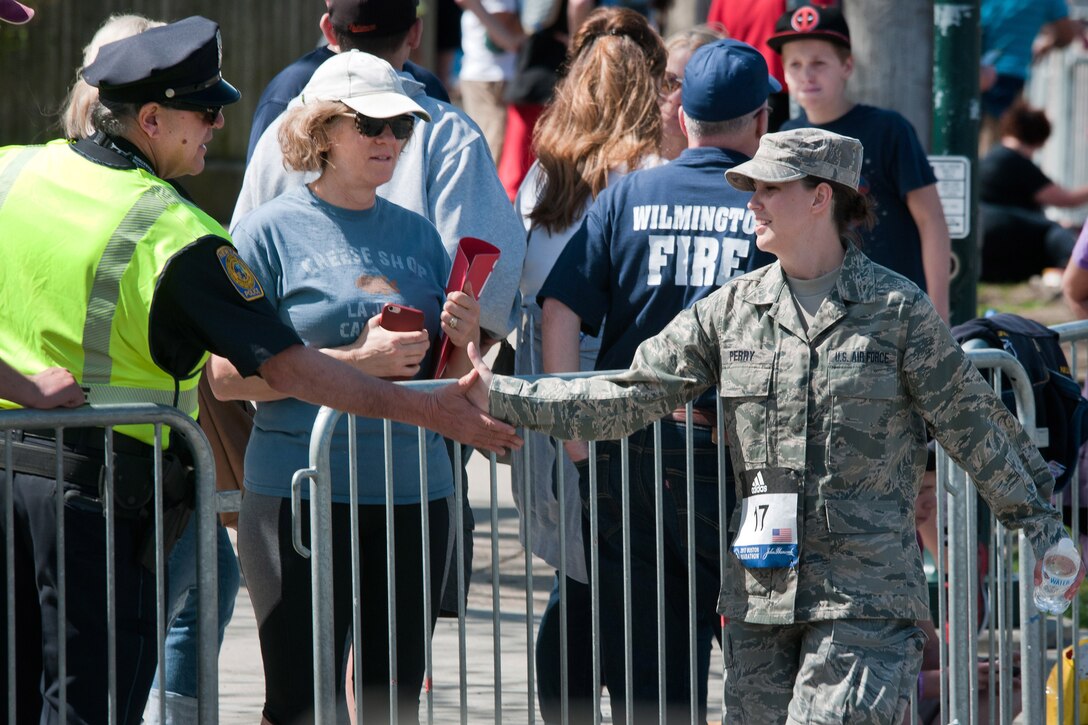 A Massachusetts Air National Guardsman shakes hands with a law enforcement officer while participating in the 121st Boston Marathon in Newton, Mass., April 17, 2017. Dozens of Massachusetts National Guardsmen particiapted in the  marathon and assisted law enforcement with security. Army National Guard photo by Staff Sgt. Evan Lane