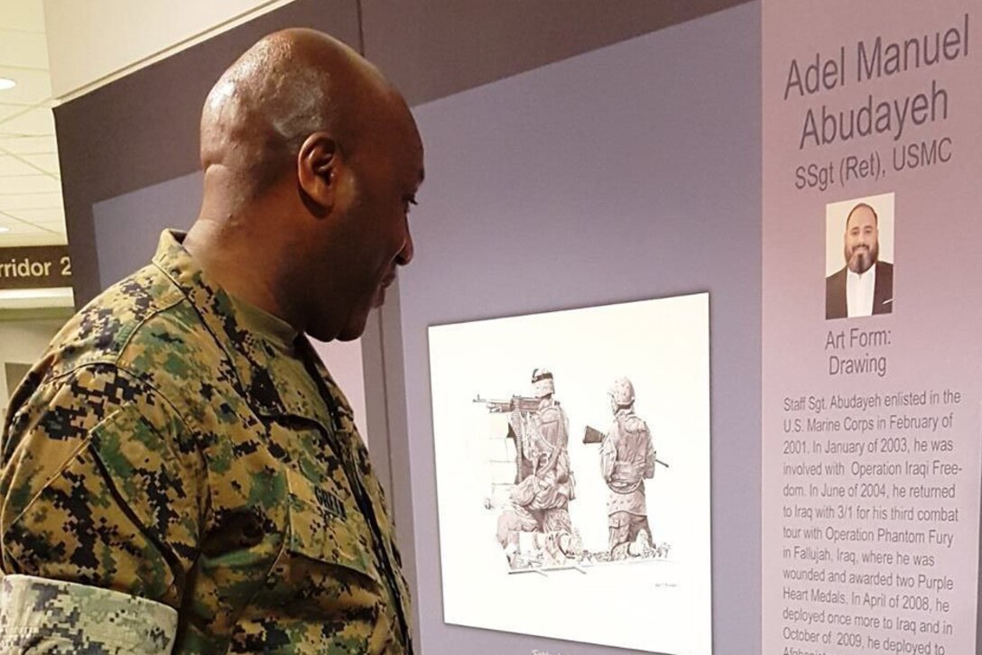 Sgt. Maj. of the Marine Corps Ronald L. Green reads the biography of retired Marine Staff Sgt. Adel Abudayeh whose artwork is on display at the Pentagon Patriotic Art Program: Wounded Warrior Healing Arts exhibit, April 12, 2017. Marine Corps photo by Victoria Long