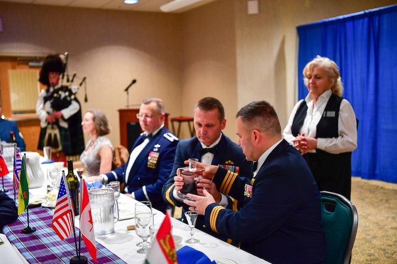 Canadian Brig. Gen. David Cochrane, 2nd Canadian Air Division commander, pass the port to Canadian Lt. Col. Matt Wappler, Wester Air Defense Sector Canadian Detachment commander, during the annual Canadian Mess Dinner marking the 93rd anniversary of the formation of the Royal Canadian Air Force.  The manner in which the port is passed is military service specific.  In case of the Air Force, the port never touches the table to symbolize flight.  The port is used for all of the official toasts during the Mess Dinner.  (U.S. Air Force photo by Kimberly D. Burke)