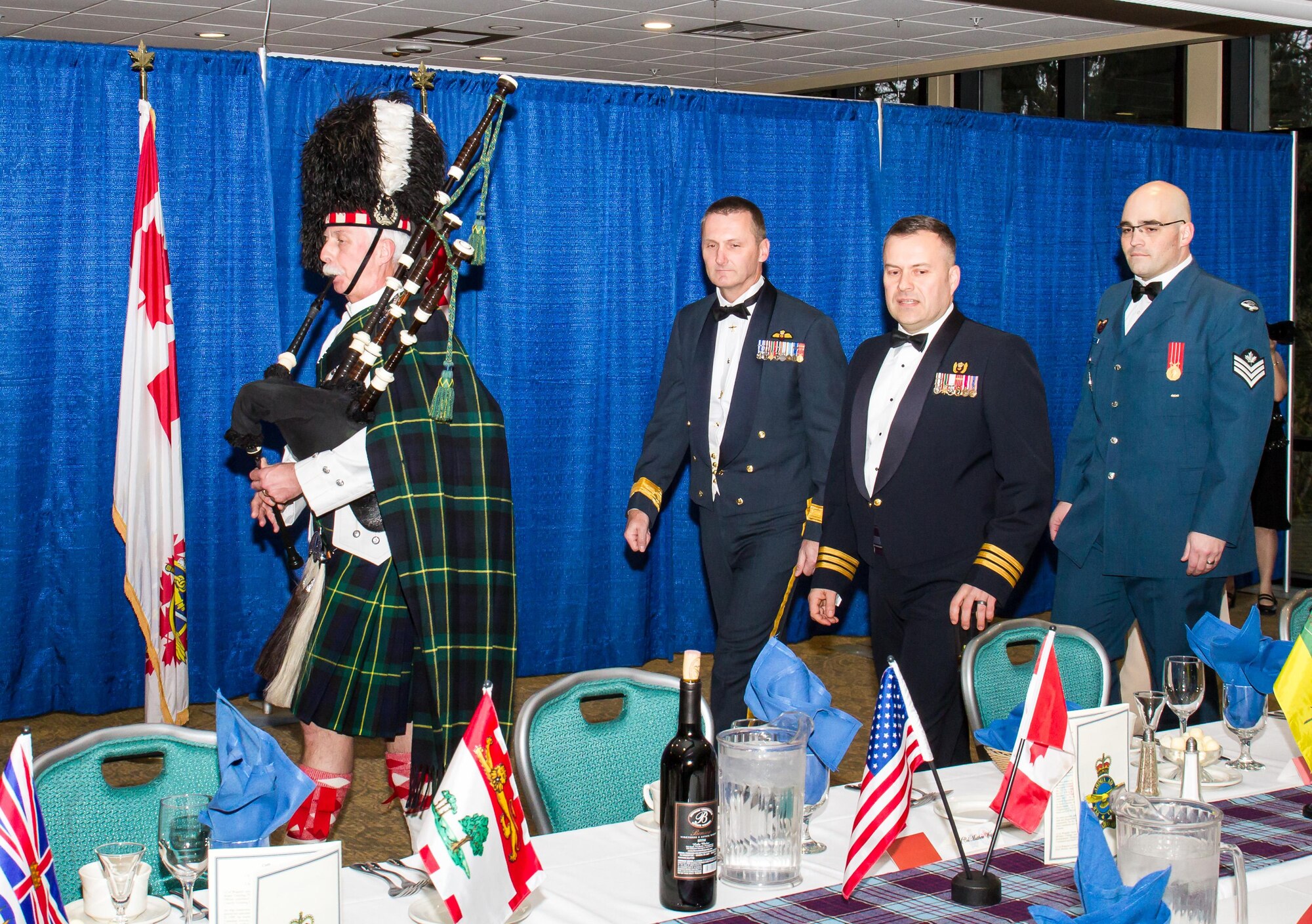 Canadian Brig. Gen. David Cochrane (second from left), 2nd Canadian Air Division commander and Canadian Lt. Col. Matt Wappler (second from right), Western Air Defense Sector Canadian Detachment commander, are led by bagpiper Van Bradley symbolizing the start of the Canadian Mess Dinner.  The annual dinner marked the 93rd anniversary of the formation of the Royal Canadian Air Force (RCAF).  At the end of the night, Cochrane formally recognized WADS with the 2nd CAD Commander’s Unit Commendation for providing critical live and virtual training to Canadian aerospace controllers from the 51 Aerospace Control and Warning (Operational Training) Squadron located in North Bay, Ontario. (Courtesy photo by Conrad Neumann III)