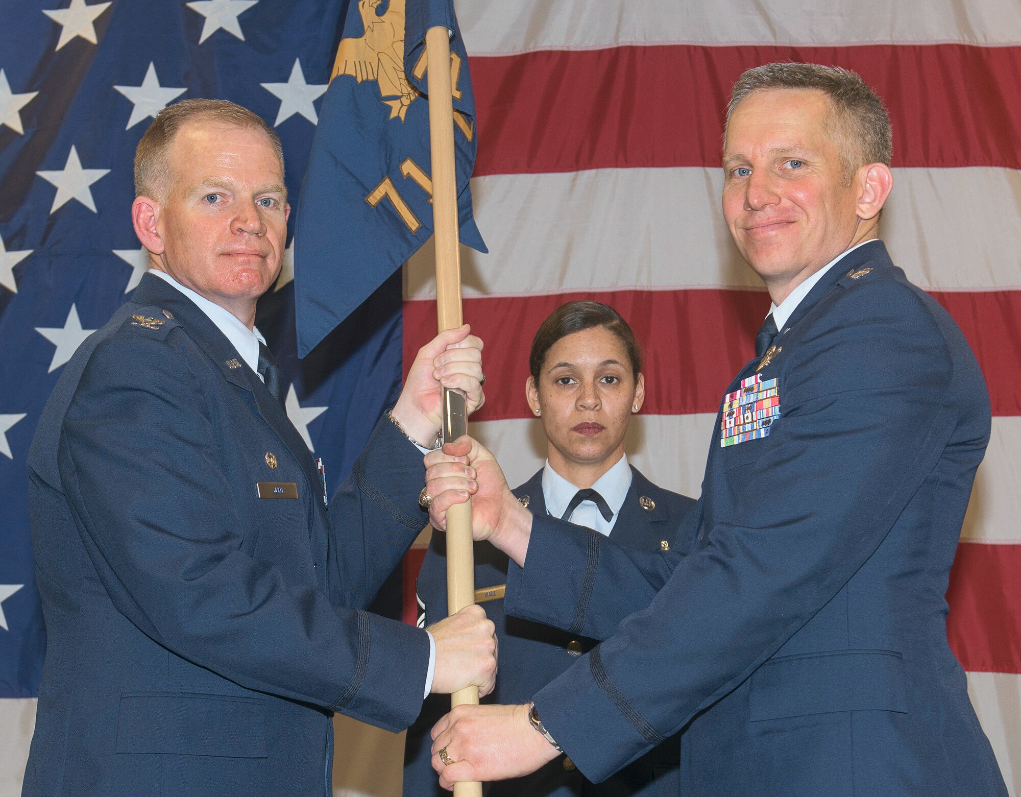 Lt. Col. Michael Kirkpatrick, right, accepts the guidon and command of the 71st Operations Support Squadron from Col. Darrell Judy, 71st Flying Training Wing commander, during a ceremony held April 17 at Vance AFB, Oklahoma. In the background is Master Sgt. Daira Hall, the 71st Operations Group first sergeant. (U.S. Air Force photo/ Terry Wasson)