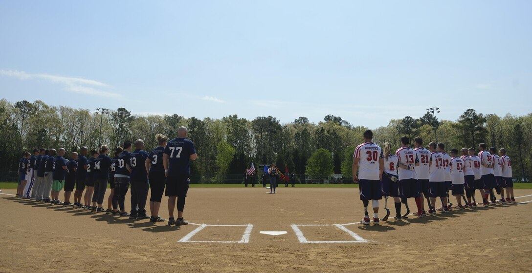 The Wounded Warrior Amputee Softball Team stand with the Newport News police and fire departments during the playing of the national anthem at the WWAST game in Newport News, Va., April 15, 2017. The WWAST is comprised of veterans and active-duty members who have lost limbs while serving in the military since 9/11. (U.S. Air Force photo/Airman 1st Class Kaylee Dubois)