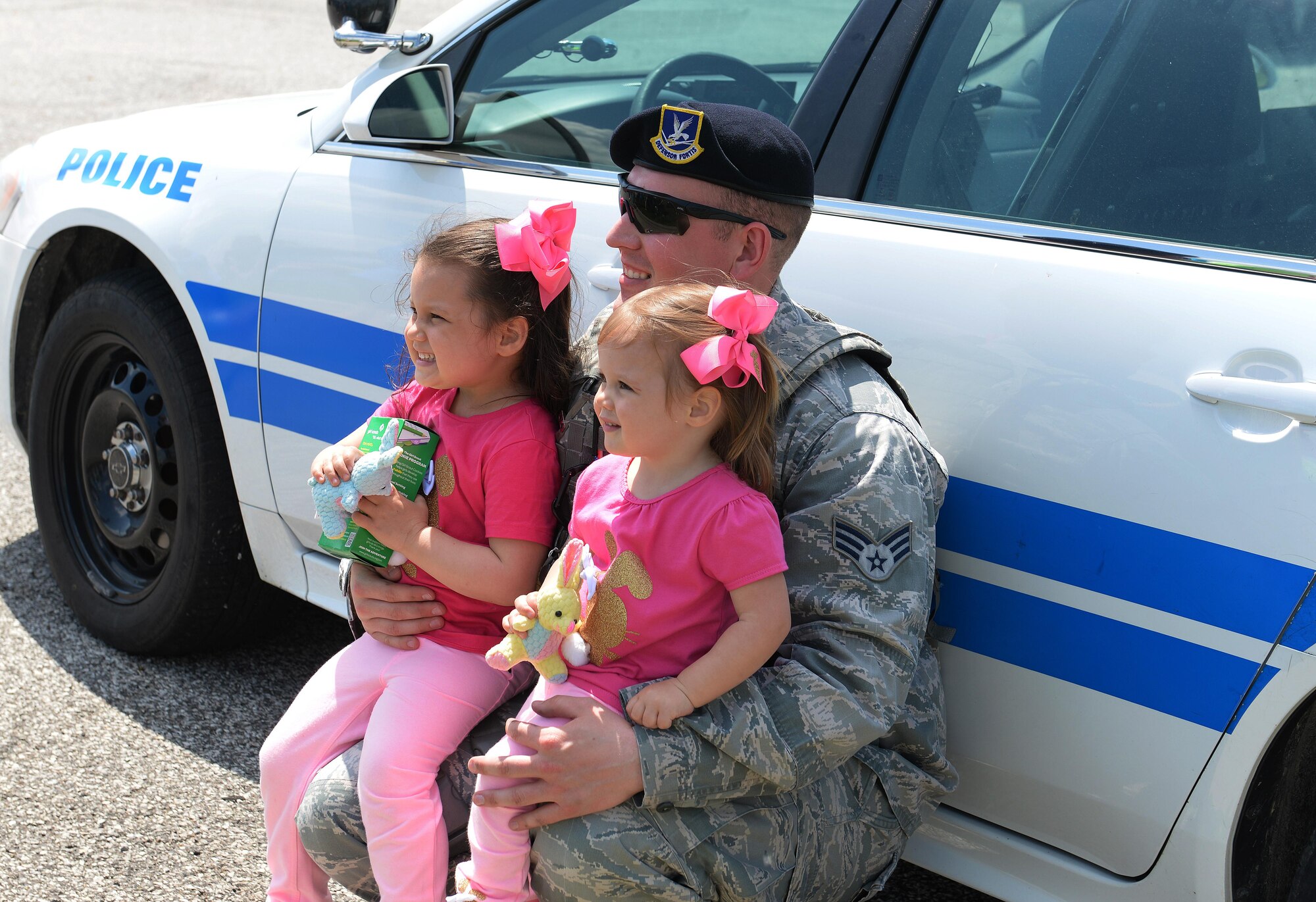 Senior Airman Kyle Sowards, 375th Security Forces Squadron patrolman, poses with children attending the Egg Hunt Egg-Stravaganza, Scott Air Force Base, Ill., April 15, 2017. 375th SFS Airmen talked to crowds of families about their jobs and let children see what it was like to sit inside their various vehicles. (U.S. Air Force photo by Senior Airman Erica Fowler)