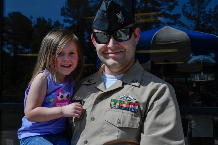 Petty Officer 1st. Class Robert Bromley, Naval Nuclear Power Training Command, holds his daughter, Madelynn, at the Joint Base Charleston-Weapons Station Child Development Center, April 13, 2017. April was named Month of the Military Child by former Defense Secretary Casper Weinberger in 1989 to applaud military children for their daily sacrifices and the challenges they have overcome. WS CDC is celebrating Month of the Military Child by hosting Wacky Hat Wednesdays, Purple Up! Fridays and planting gardens with parents and students.