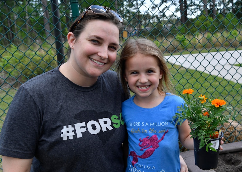 Petty Officer 2nd. Class Nichole Johnson and her daughter Sophia plant flowers at the Joint Base Charleston-Weapons Station Child Development Center, April 13, 2017. April was named Month of the Military Child by former Defense Secretary Casper Weinberger in 1989 to applaud military children for their daily sacrifices and the challenges they have overcome. The WS CDC is celebrating Month of the Military Child by hosting Wacky Hat Wednesdays, Purple Up! Fridays and planting gardens with parents and students.