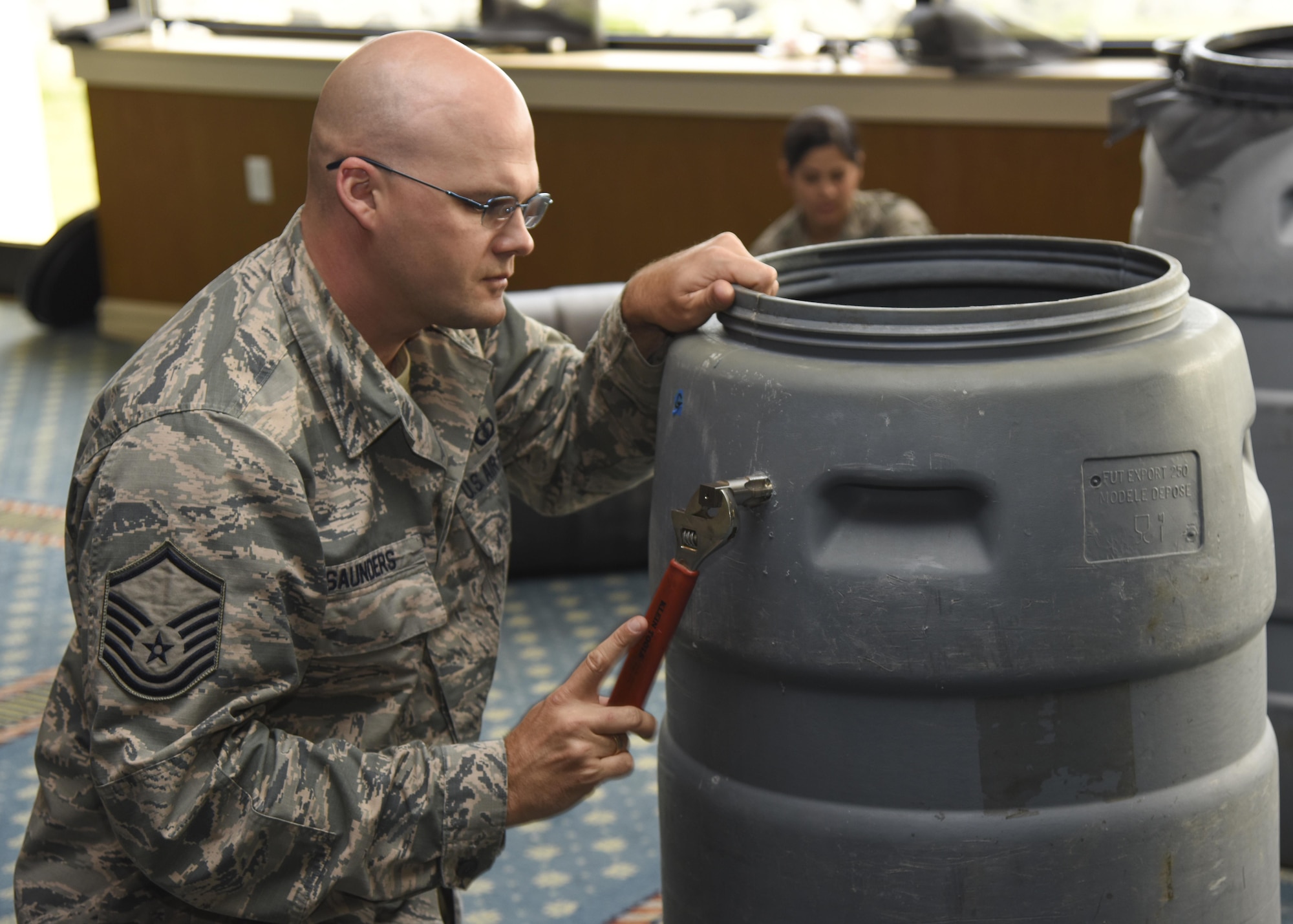 U.S. Air Force Master Sgt. Jefferey Saunders, 633rd Mission Support Group environmental manager, prepares to insert a drainage tube into a rain barrel during a rain harvesting workshop at Joint Base Langley-Eustis, Va., April 17, 2017. According to Ronald Best, 633rd Civil Engineer Squadron environmental flight pollution prevention manager, storm water run-off carries fertilizers, pesticides and pet waste to streams, and is the number one cause of pollution. (U.S. Air Force photo/Airman 1st Class Anthony Nin Leclerec)