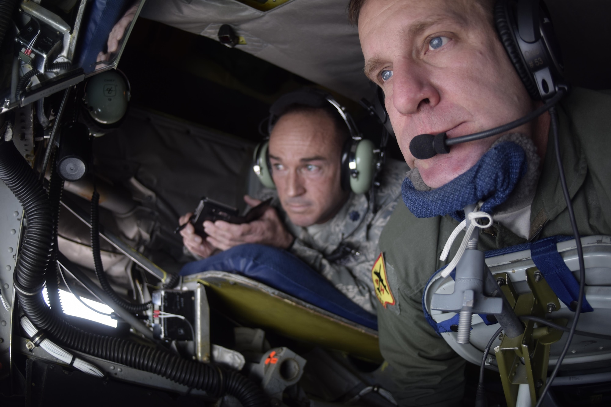 Master Sgt. Charles Danten, 465th Air Refueling Squadron, 507th Air Refueling Wing, Air Force Reserve Command, looks down on F-16s during a air refueling mission while Lt. Col. Lance Winner, 513th Air Control Group deputy commander, watches the action in the background April 6, 2017, from Tinker Air Force Base, Oklahoma. The 507th ARW conducted a local training flight with members of the Tinker Air Force Base Honorary Commander's 2017 Class to learn about the KC-135R Stratotanker's mission during an air refueling mission with F-16s of the 138th Fighter Wing, Oklahoma Air National Guard. (U.S. Air Force photo/Greg L. Davis)