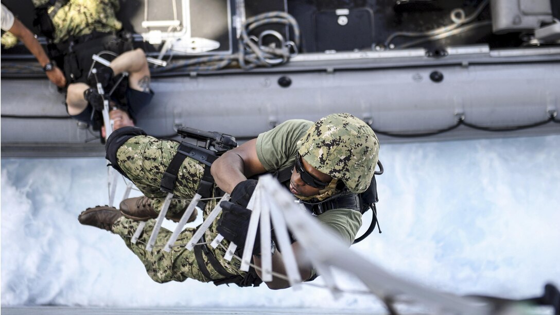 Navy Petty Officer 2nd Class Patrick W. Holmes climbs a hook ladder while boarding the USS Carter Hall during Alligator Dagger 17 in the Gulf of Aden, April 12, 2017. The exercise provides an opportunity to enhance multilateral capabilities in critical mission sets inherent to the Navy and Marine Corps. Navy photo by Petty Officer 1st Class Darren M. Moore