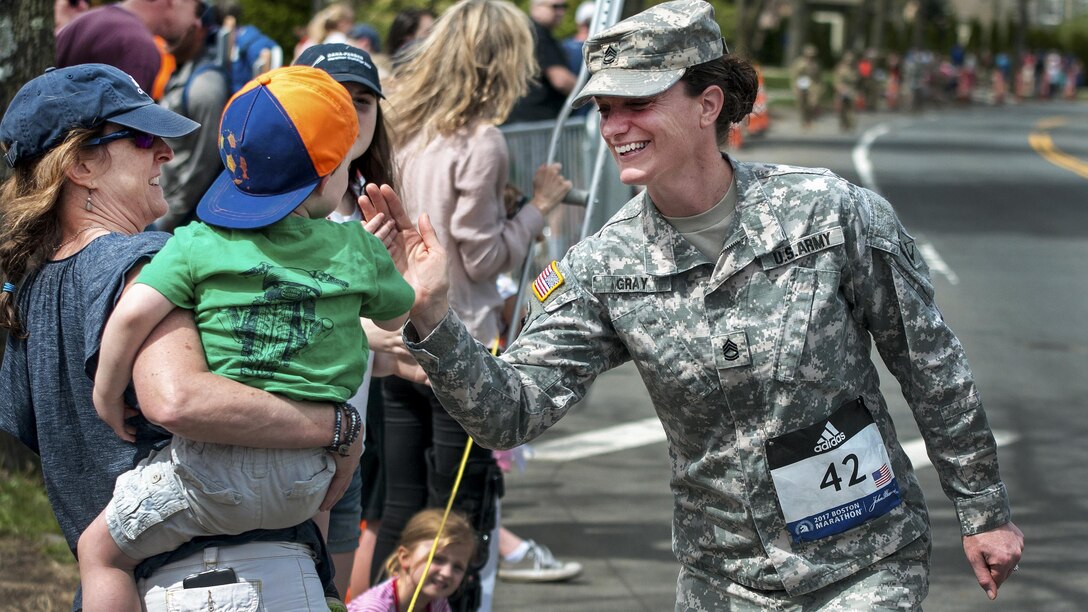 A Massachusetts Army National Guardsman high-fives a child while participating in the 121st Boston Marathon in Newton, Mass., April 17, 2017. Dozens of Massachusetts Guardsmen participated in the marathon as well as assisted local law enforcement with security. Army National Guard photo by Staff Sgt. Evan Lane
