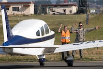 Lt. Col. Adam Boyd, Civil Air Patrol National HQ-103 commander, and Cadet Master Sgt. Simon Amport, CAP cadet, marshal in a civilian aircraft landing at Yokota Air Base, Japan, during the Kanto Plain Mid-Air Collision Avoidance Conference, April 15, 2017. The conference brought together military and civilian pilots from all over Japan to focus on flight safety and base flight procedures. (U.S. Air Force photo by Yasuo Osakabe)