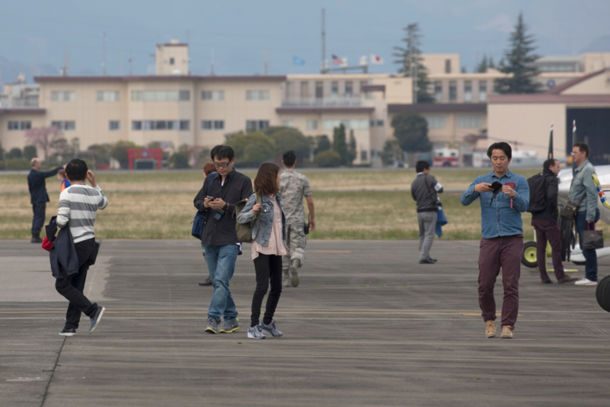 Participants walk on the flightline after landing at Yokota Air Base, Japan, during the Kanto Plain Mid-Air Collision Avoidance Conference, April 15, 2017. The conference brought together military and civilian pilots from all over Japan to focus on flight safety and base flight procedures. (U.S. Air Force photo by Yasuo Osakabe)