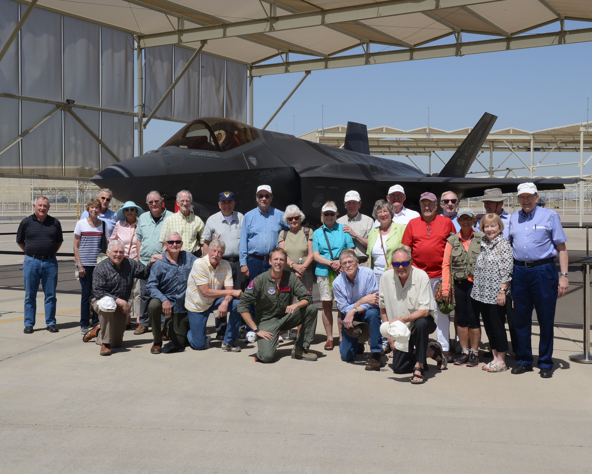 Maj. Hunter Powell, 63rd Fighter Squadron F-35 Lightning II instructor pilot, and the Undergraduate Pilot Training class of 1967 pose for a group photo after visiting the 63rd FS April, 12, 2017, at Luke Air Force Base, Ariz. The UPT class was able to see the F-35 up close and learn how Luke is building the future of airpower. (U.S. Air Force photo by Senior Airman James Hensley)