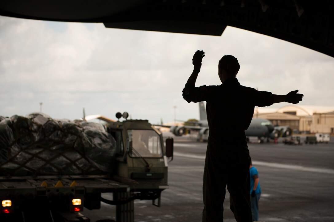 Senior Airman Korina Myers, loadmaster assigned to the 535th Airlift Squadron, directs cargo loading on a C-17 Globemaster III during Exercise TROPIC THUNDER 2017 (XTT17), Joint Base Pearl Harbor-Hickam, Hawaii, April 19, 2017. XTT17 is a two part full spectrum readiness exercise hosted by the 15th Wing to test the individual, organizational and expeditionary readiness of the Airmen stationed at Hickam Field. (U.S. Air Force photo by Tech. Sgt. Heather Redman)