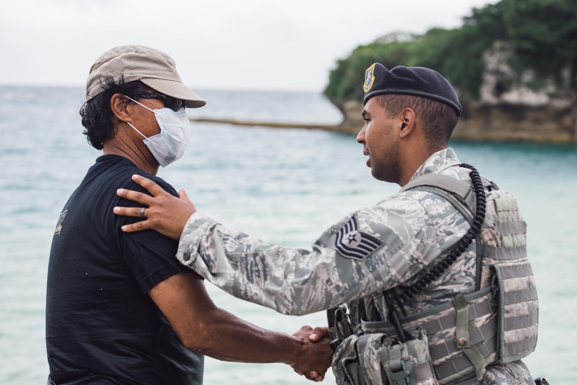 U.S. Air Force Tech. Sgt. Oswaldo Cerrato, 18th Security Forces Squadron flight lead, thanks U.S. Air Force retired Master Sgt. David Lacar for his efforts in the rescue of a dwarf sperm whale April 17, 2017, at Kadena Marina, Japan. Lacar was relieved by 18th Force Support Squadron divers after supporting the injured dwarf sperm whale for more than two hours. (U.S. Air Force photo by Senior Airman Omari Bernard/Released)