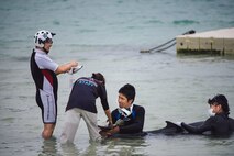 Dr. Keiichi Ueda, Charumi Aquarium veterinarian, readies an IV for an injured dwarf sperm whale April 17, 2017, at Kadena Marina, Japan. The veterinarian team disinfected the wounds of the whale while taking blood samples and monitoring its condition. (U.S. Air Force photo by Senior Airman Omari Bernard/Released)