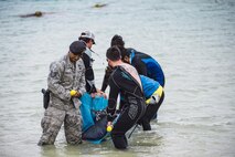 U.S. Air Force Tech. Sgt. Oswaldo Cerrato, 18th Security Forces Squadron flight lead and on-scene commander, helps carry an injured dwarf sperm whale in a stretcher April 17, 2017, at Kadena Marina, Japan. The dwarf sperm whale, known as the smallest species of whale, weighed 330 pounds. (U.S. Air Force photo by Senior Airman Omari Bernard/Released)