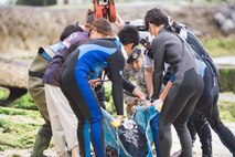 A makeshift rescue team of Okinawan veterinarians, bystanders, and personnel from the 18th Security Forces Squadron and 18th Force Support Squadron secure an injured dwarf sperm whale to a crane April 17, 2017, at Kadena Marina, Japan. The makeshift team successfully and safely loaded the whale aboard the transport vehicle via crane. (U.S. Air Force photo by Senior Airman Omari Bernard/Released)