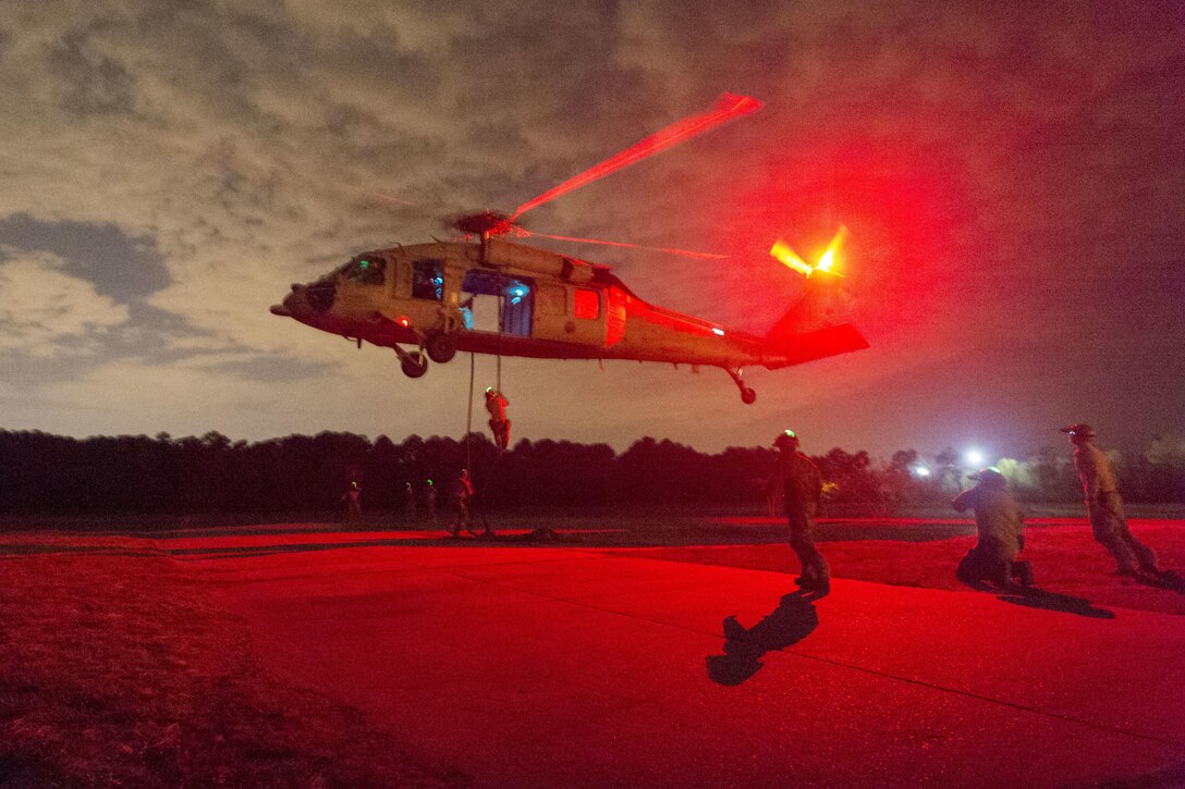 Sailors fast-rope from an MH-60S Seahawk helicopter during training for rope-suspension techniques at Joint Expeditionary Base Fort Story in Virginia Beach, Va., April 12, 2017. The seaman are assigned to Explosive Ordnance Disposal Group 2. Navy photo by Petty Officer 2nd Class Charles Oki