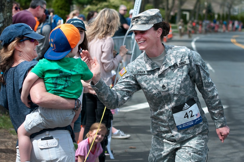 A Massachusetts Army National Guardsman high-fives a child while participating in the 121st Boston Marathon in Newton, Mass., April 17, 2017. Dozens of Massachusetts National Guardsmen participated in the marathon as well as assisted local law enforcement with security.  Army National Guard photo by Staff Sgt. Evan Lane
