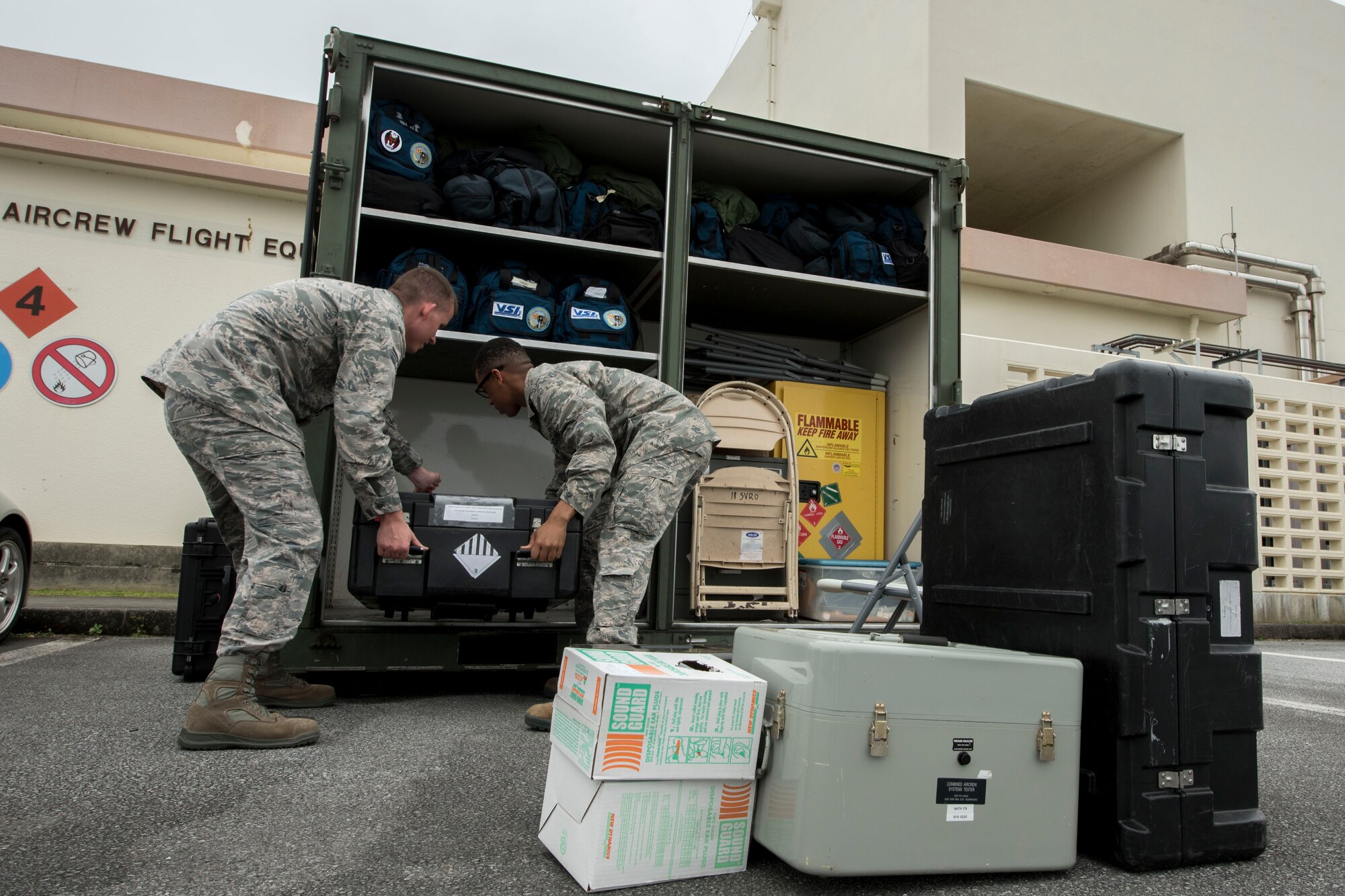 U.S. Air Force Senior Airman Joseph Gago and Airman Nigel Simpson, 18th Operations Support Squadron aircrew flight equipment technicians assigned to the 44th Fighter Squadron, stow away equipment April 18, 2017, at Kadena Air Base, Japan. The AFE team prepares members of the 44th FS to participate in aviation training relocation programs in different parts of the world, such as Guam. (U.S. Air Force photo by Senior Airman John Linzmeier)