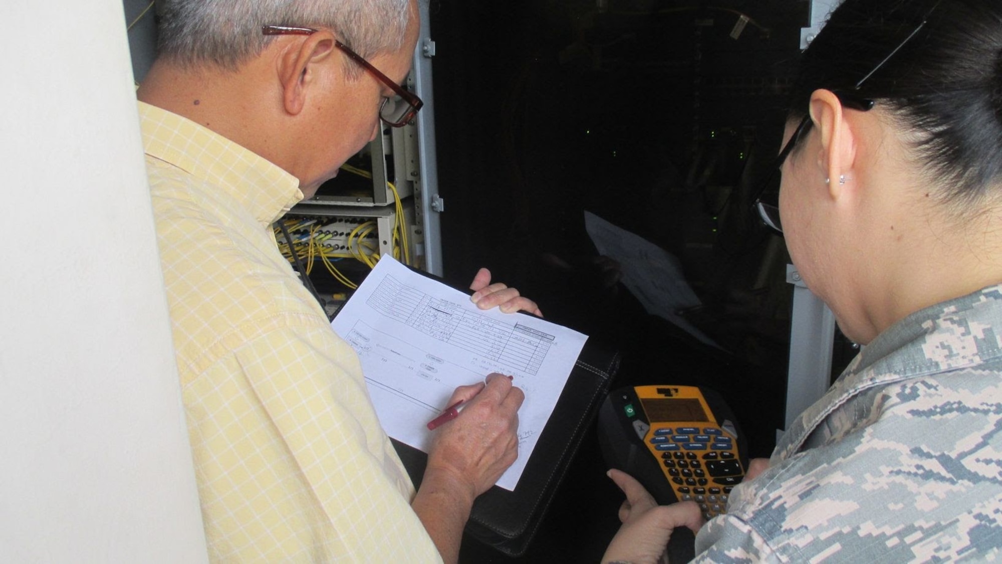 An engineer from the 38th Cyberspace Engineering Installation Group and 18th Communications Squadron identify wire locations March 28, 2017, at Kadena Air Base, Japan. The 38th CEIG assisted the 18th CS in reducing the number of routers by 25 percent. This reduction is estimated to save the Air Force more than $750,000 in maintenance costs annually. (Courtesy photo)