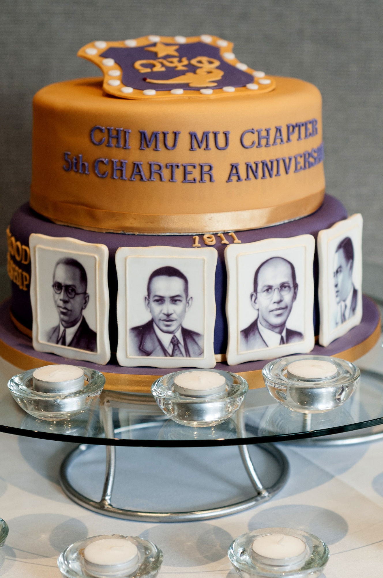 The newest and the oldest members, present at the event, cut the Chi Mu Mu Chapter Fifth Anniversary cake, April 15, 2017, at a banquet in Birmingham, England. Chi Mu Mu is the U.K. chapter of the Omega Psi Phi Fraternity, headquartered in the States. Personnel from RAF Mildenhall and RAF Lakenheath, England, were invited to the evening as members and patrons. (courtesy photo)