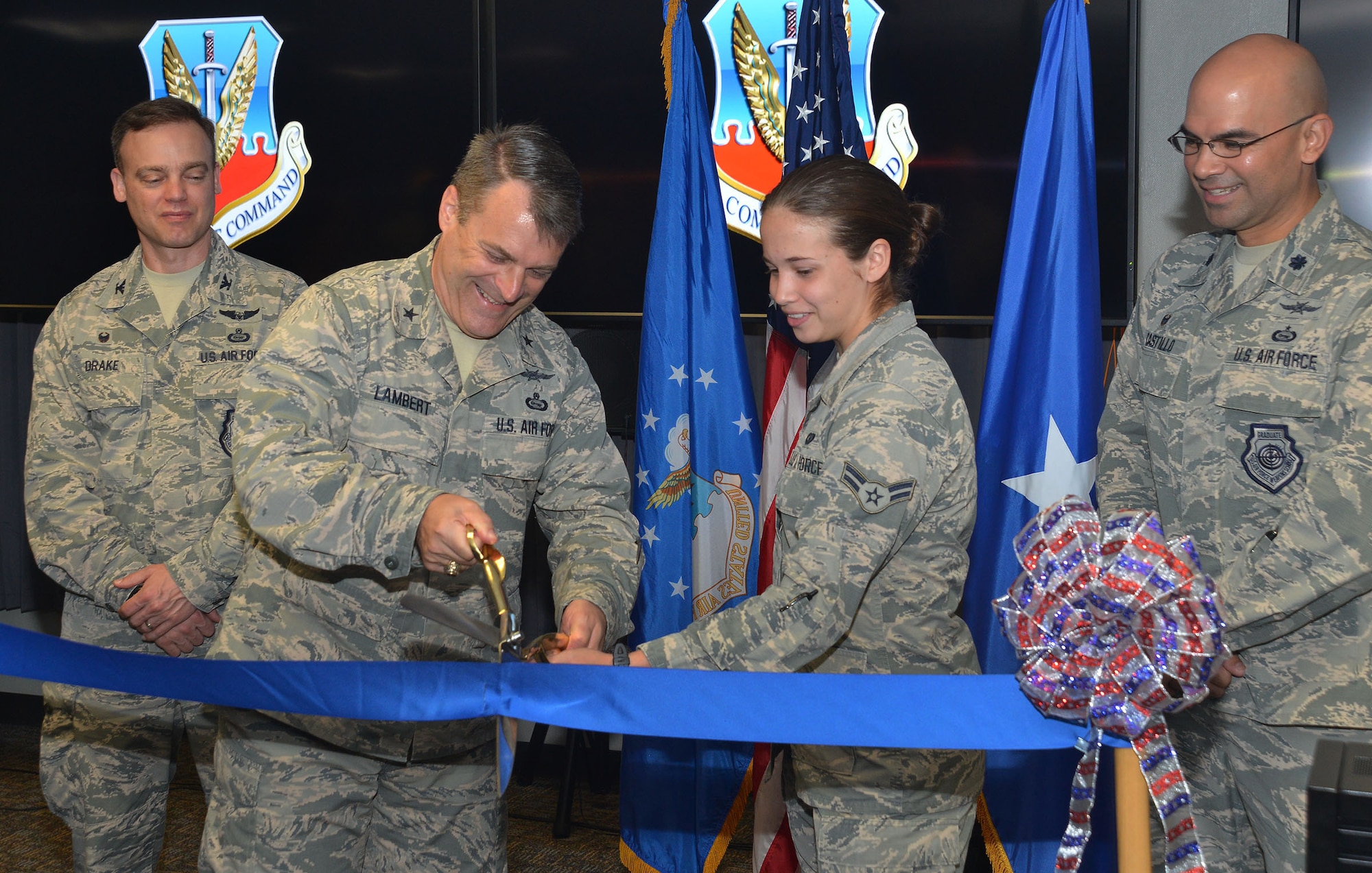 Brig. Gen. Peter Lambert, director of intelligence, Headquarters Air Combat Command, and Airman 1st Class Maggie, the youngest Airman assigned to the CTIC, 35th Intelligence Squadron, open the Cyberspace Threat Intelligence Center during the ribbon cutting ceremony Apr. 10. (U.S. Air Force photo by Lori Bultman)