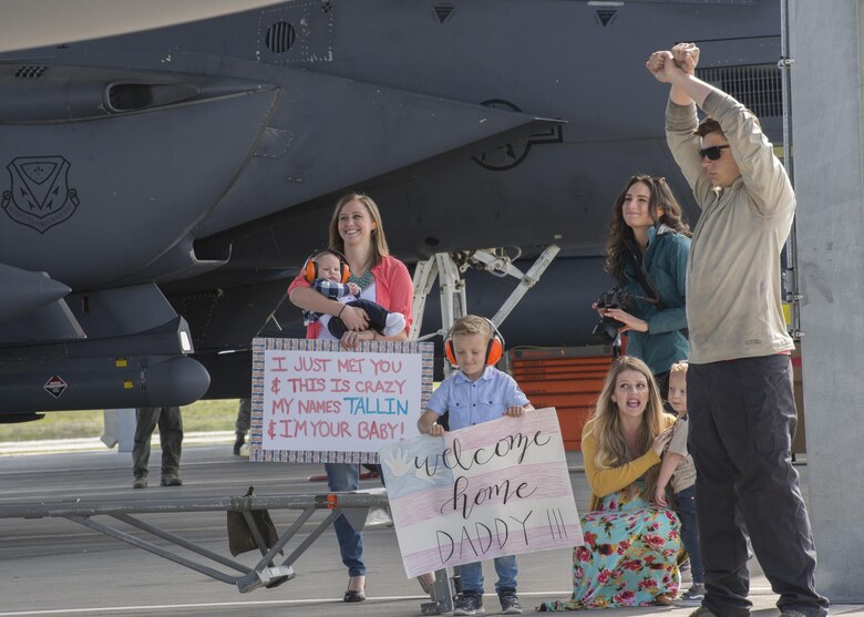 Family members wait while a crew chief directs an F-15E Strike Eagle to hold its position at Mountain Home Air Force Base, Idaho, April 8, 2017. Approximately 20 jets and 500 airmen returned that week after deploying for six months in support of Operation Inherent Resolve. (U.S. Air Force photo by Airman Jeremy D. Wolff)