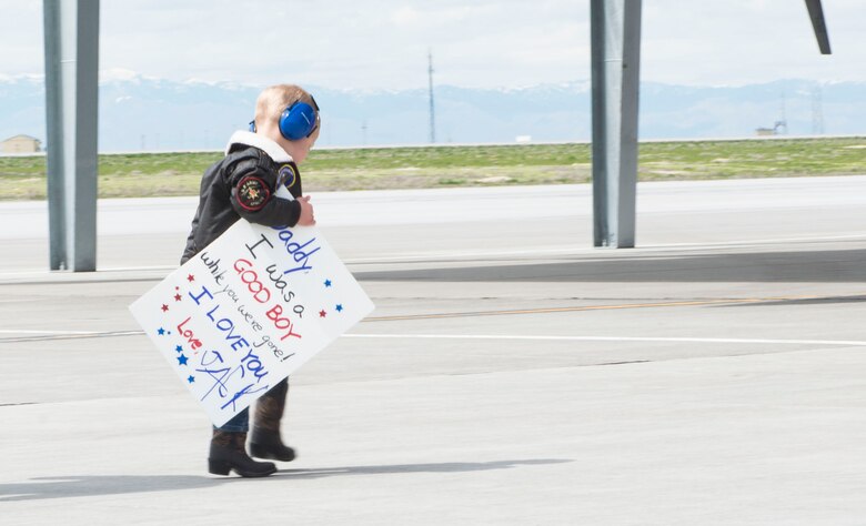 A reunited family embraces during a homecoming of deployed members, April 12, 2017, at Mountain Home Air Force Base, Idaho. More than 5,000 munitions were dropped on ISIS targets in support of Air Forces Central Command. (U.S. Air Force photo by Senior Airman Malissa Lott/Released)