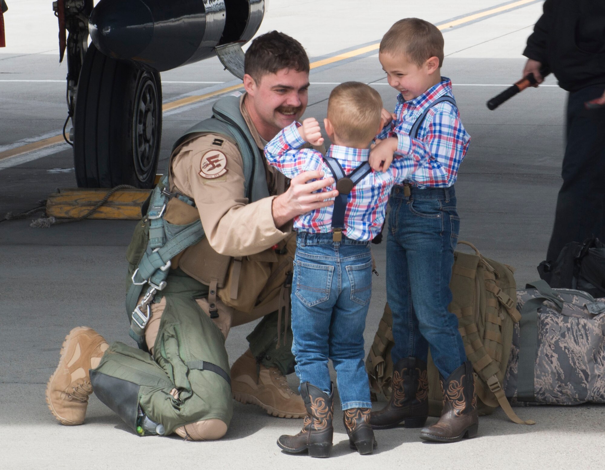 Two boys laugh with excitement over their fathers return from a six month deployment, April 10, 2017, at Mountain Home Air Force Base, Idaho. Airmen were deployed in support of Operation Inherent Resolve in Southwest Asia. (U.S. Air Force photo by Senior Airman Malissa Lott/Released)