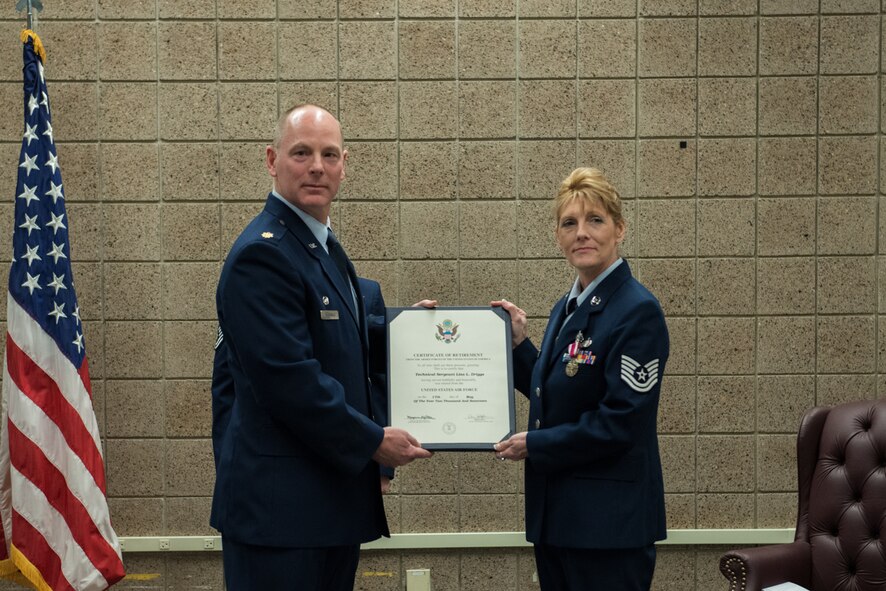 Maj. Patrick McDonald, 934th Communications Squadron commander, presents TSgt Lisa L. Driggs, 934th Communications Squadron, with her Certificate of Retirement April 1 at Minneapolis-St. Paul Air Reserve Station, Minn. (U.S. Air Force photo by Senior Airman Samuel Wacha)