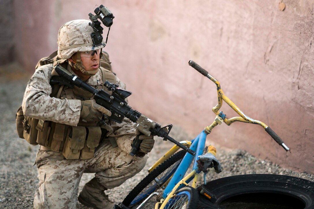 A Marine provides security in an urban operations city during a heavy-Huey raid as part of Weapons and Tactics Instructors course 2-17 at Yuma Proving Grounds, Ariz., April 12, 2017. The Marine is assigned to 2nd Battalion, 6th Marine Regiment. The exercise was designed to focus on executing a company air assault raid supported by fixed and rotary wing escorts and employing aviation weapons and tactics. Heavy-Huey raids utilize the UH-1Y Huey and the heavier CH-53E Super Stallion helicopters. Air Force photo by Tech. Sgt. Chris Hibben
