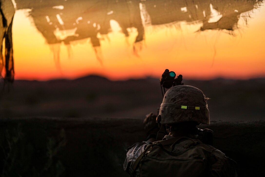 A Marine scans his sector at sunset while providing security during a heavy-Huey raid as part of Weapons and Tactics Instructors course 2-17 at Yuma Proving Grounds, Ariz., April 12, 2017. Air Force photo by Tech. Sgt. Chris Hibben