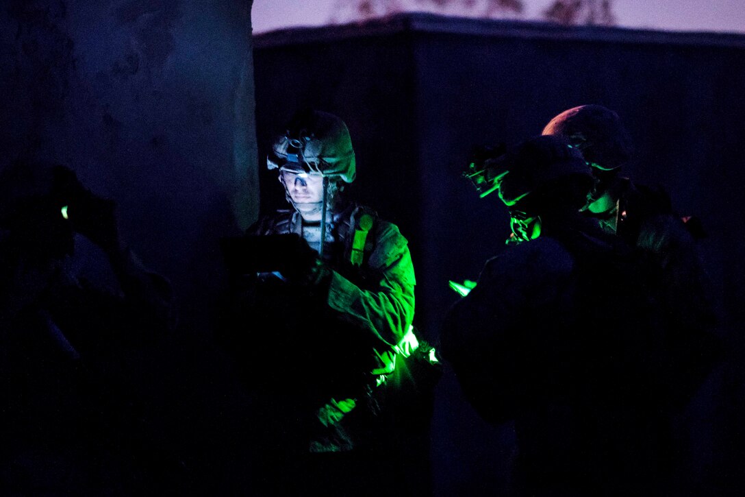 Marines use their tablets to synchronize time and grid coordinates for their next objective during a heavy-Huey raid as part of Weapons and Tactics Instructors course 2-17 at Yuma Proving Grounds, Ariz., April 12, 2017. Air Force photo by Tech. Sgt. Chris Hibben