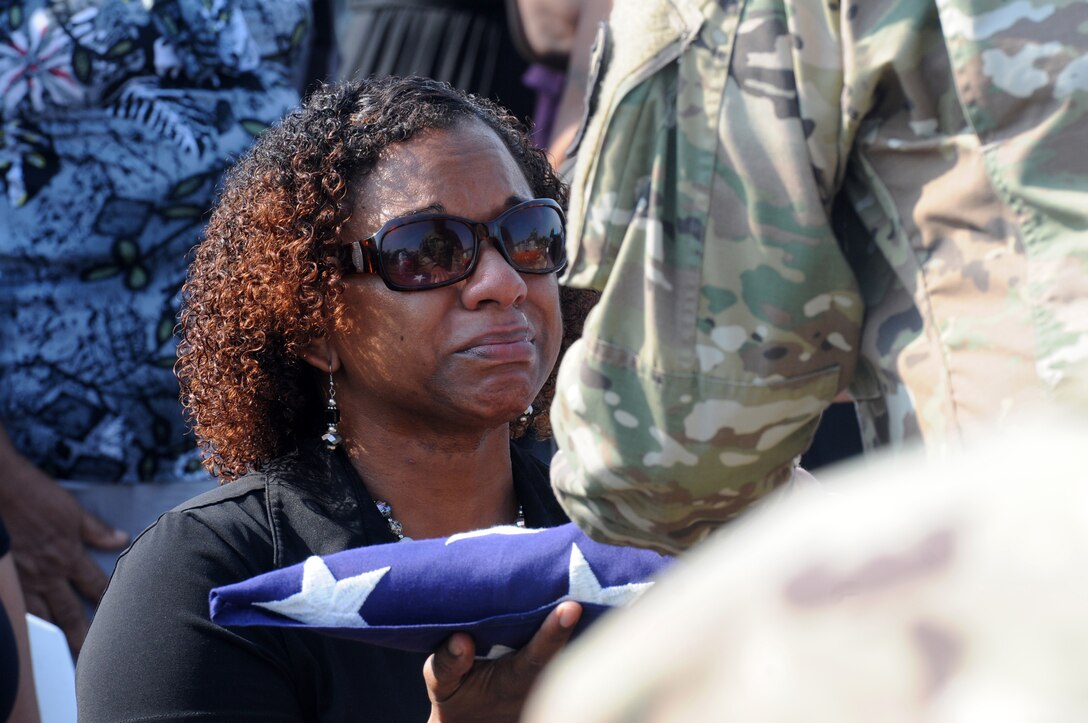 Deshana Pandy receives a folded American flag from Command Sgt. Major Angel Rivera at a funeral detail for her father, 22-year Army veteran Master Sgt. David Daniel Alexander Pandy Jr., at a cemetery in Ladyville, Belize on March 30, 2017. The sergeant major is a reservist from Puerto Rico’s 210th Regional Support Group assigned to Beyond the Horizon 2017-Belize, a U.S.-Belize partnership exercise encompassing three health care events and five construction projects designed to improve the health and education infrastructure of Belizean communities.