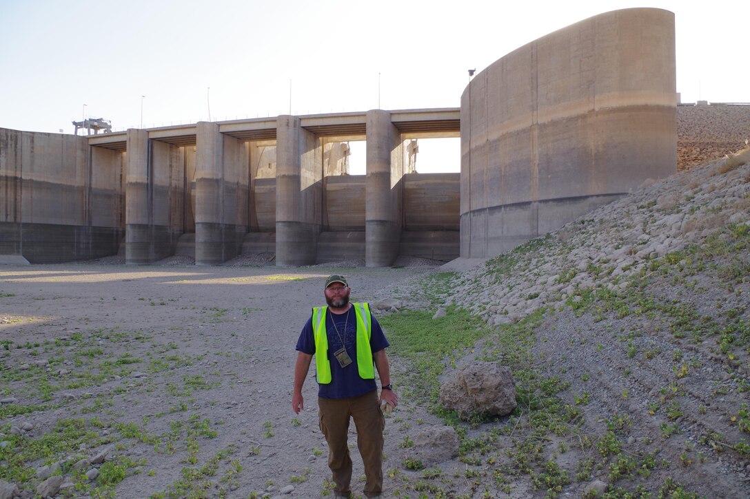 Jason Foust, deputy construction manager for the grouting project at Mosul Dam, stands by the spillway gates Oct. 22, 2016 where they drew drawn down to alleviate pressure during the work. Foust has since returned to the U.S. Army Corps of Engineers Nashville District where he is project engineer at the Kentucky Lock Addition Project in Grand Rivers, Ky. (Photo by Charlie Krolikowski)