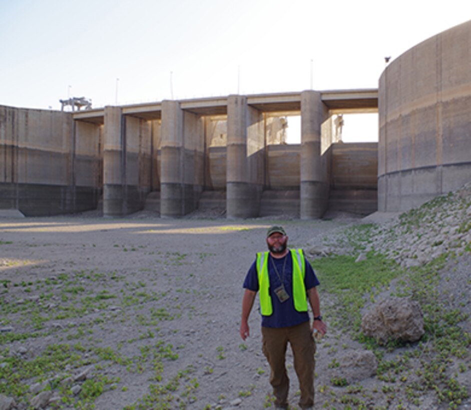 Jason Foust, deputy construction manager for the grouting project at Mosul Dam, stands by the spillway gates Oct. 22, 2016 where they drew drawn down to alleviate pressure during the work. Foust has since returned to the U.S. Army Corps of Engineers Nashville District where he is project engineer at the Kentucky Lock Addition Project in Grand Rivers, Ky. (Photo by Charlie Krolikowski)