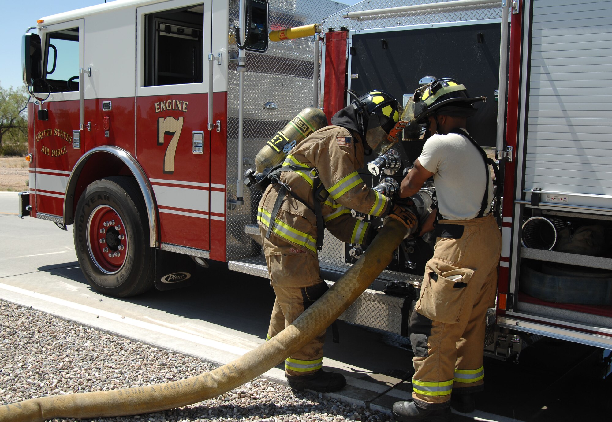 U.S. Air Force Airman 1st Class DeAndre Ward and Jacob Williams, 355th Civil Engineering Squadron firefighters, help each other connect a hose to a fire engine during fire hydrant training outside of at Davis-Monthan Air Force Base, Ariz., April 19, 2017. D-M fire fighters continuously train throughout the week in order to keep their skills honed. (U.S. Air Force photo by Airman 1st Class Frankie Moore)