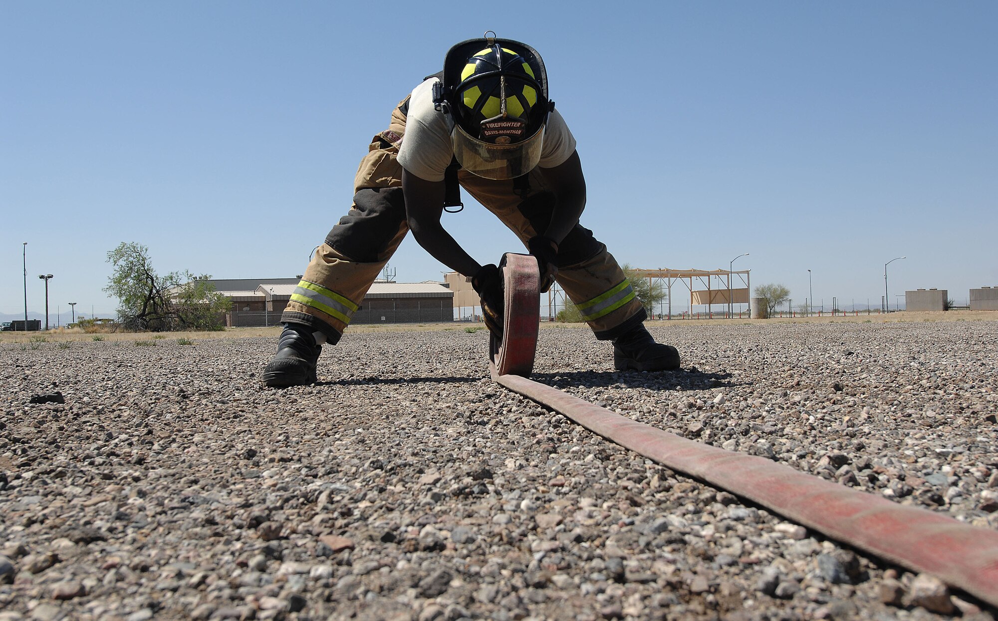 U.S. Air Force Senior Airman Haji Stewart, 355th Civil Engineering Squadron firefighter, rolls up a fire hose after a fire attack drill at Davis-Monthan Air Force Base, Ariz., April 19, 2017. The 355th CES Fire Emergency Services recently received Accredited Agency status from the Commission on Fire Accreditation International. (U.S. Air Force photo by Airman 1st Class Frankie Moore)