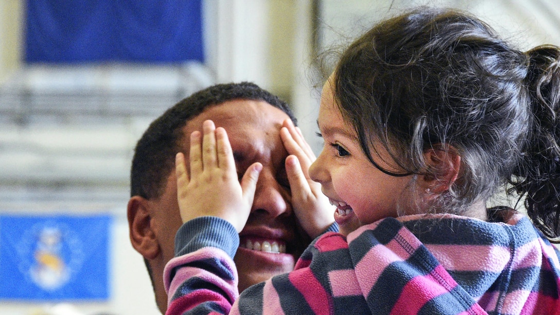 A child shares a laugh with a soldier as family members welcome troops returning to Wisconsin, April 13, 2017, following a nine-month deployment to Naval Station Guantanamo Bay, Cuba. The soldiers are assigned to the Wisconsin Army National Guard’s 32nd Military Police Company. National Guard photo by Vaughn R. Larson