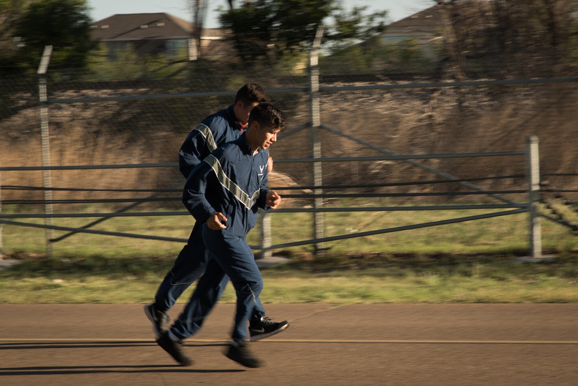 Two Airmen run down North Perimeter Road during the Arbor Day and Earth Day 5K fun run at Unity Park on Cannon Air Force Base, NM, April 19, 2017. The run was the first of three events in celebration of Earth Day and Arbor Day. (U.S. Air Force photo by Staff Sgt. Michael Washburn/Released)