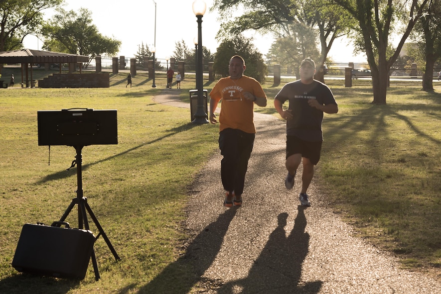 Two participants in the Arbor Day and Earth Day 5K fun run cross the finish line at Unity Park on Cannon Air Force Base, NM, April 19, 2017. The fastest time for men was 17:59 and the fastest time for women was 23:29. (U.S. Air Force photo by Staff Sgt. Michael Washburn/Released)